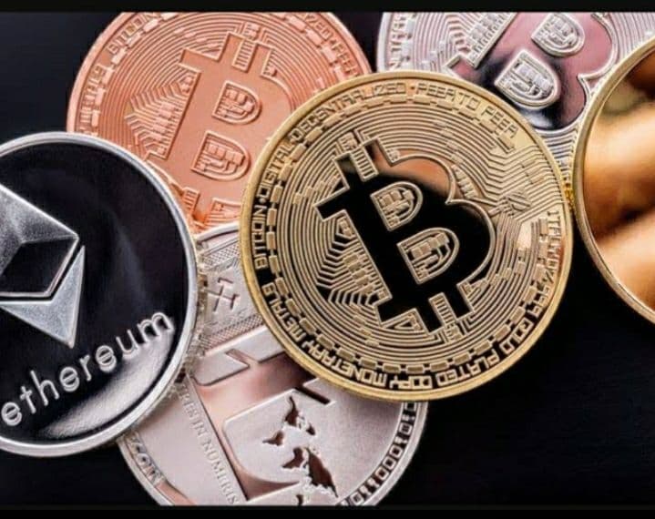 Gold Bitcoin coins stacked with financial trading charts in the background