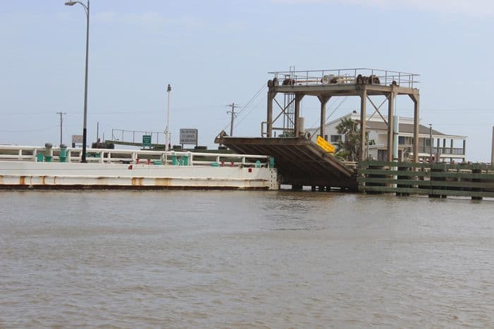 Large steel bridge spanning a river in an urban setting