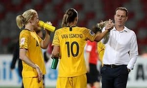Women's football match in progress on a green pitch under stadium lights