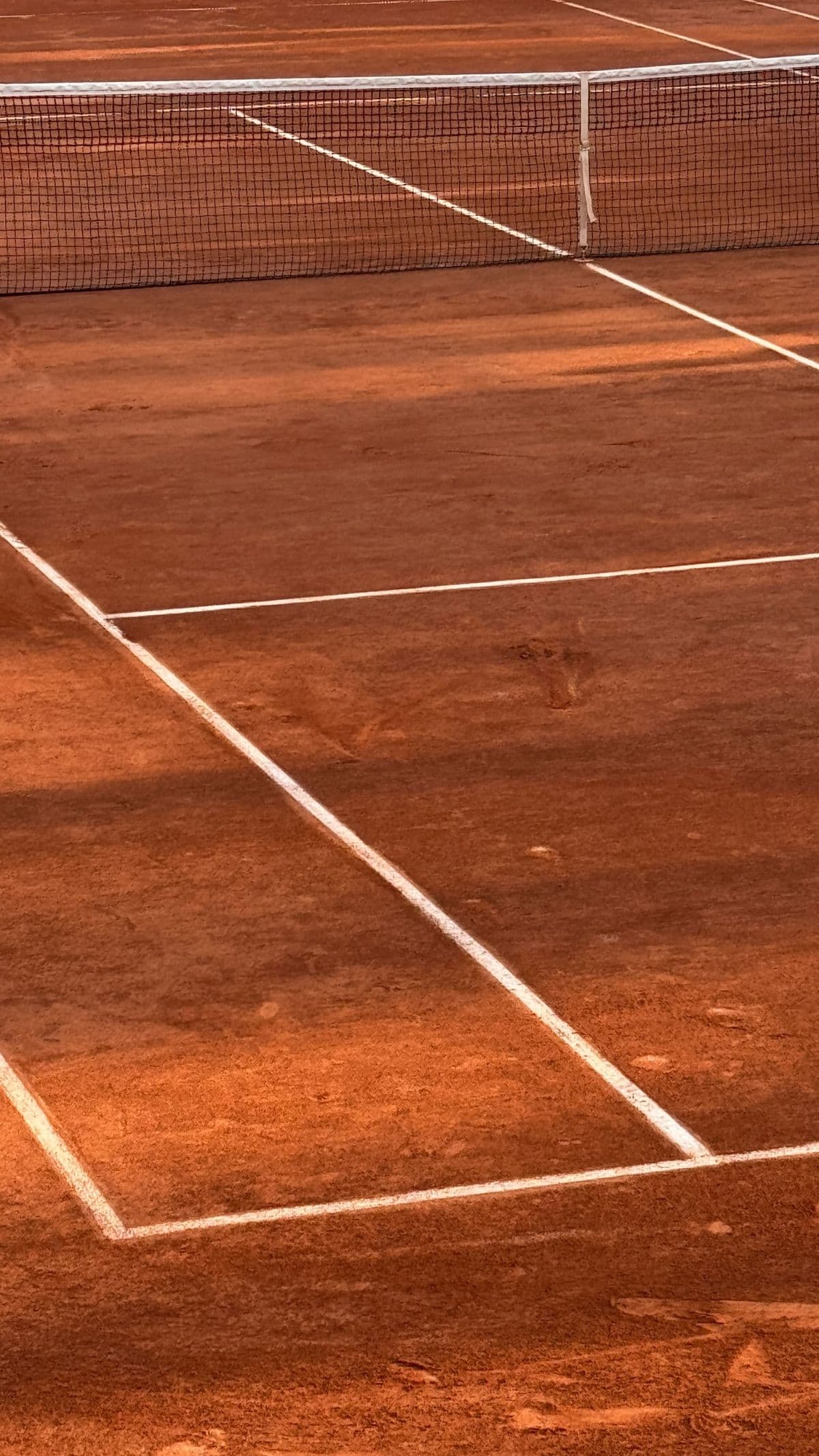 Tennis clay court with red dirt surface and white lines
