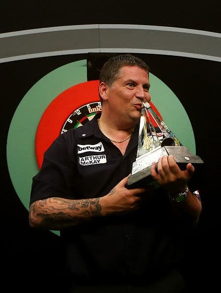 Close-up of darts hitting the bullseye on a professional dartboard