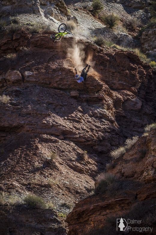 Mountain biker jumping off a cliff with desert landscape