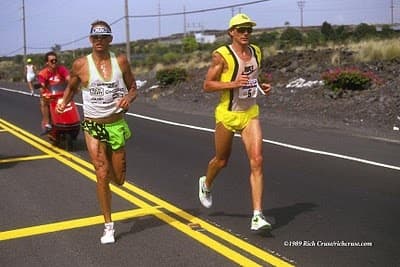 Triathlete cycling along a coastal road during an Ironman race
