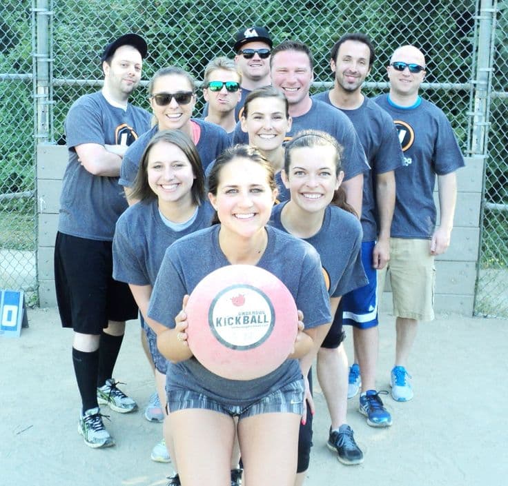 Adults playing pickleball on an outdoor court, laughing and competing