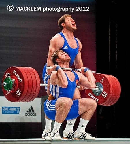Weightlifter performing a heavy snatch lift during competition