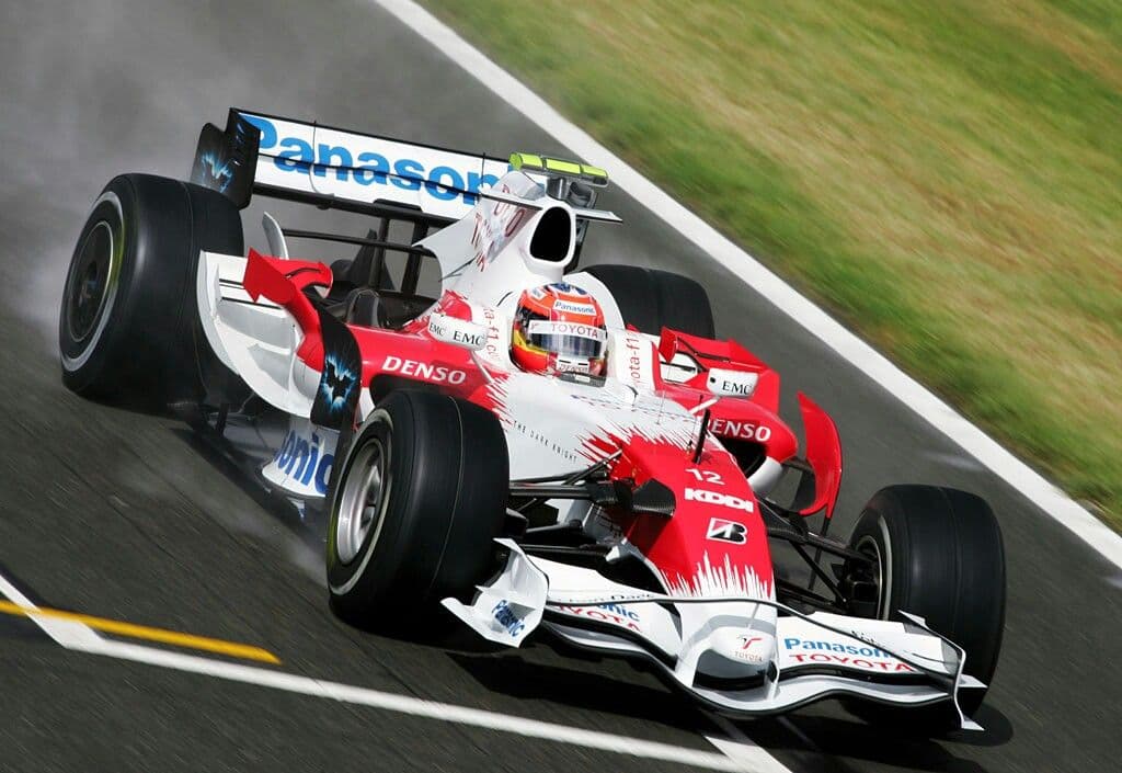 Open-wheel racing car speeding along a racetrack at high velocity
